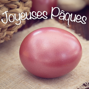 Image pour Pâques 2024 avec un œuf en chocolat rose et une phrase de voeux blanche